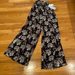 Black wide leg linen pants with slits and flowers.